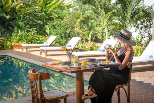 a woman sitting at a table in front of a pool at San Rafael in Mompos