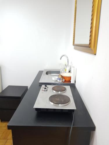 a black counter top with a stove and a mirror at Studio Buget Arena Nationala Mega Mall Monza in Bucharest