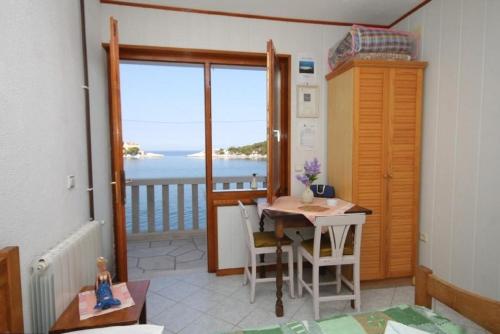 a dining room with a table and a view of the ocean at Apartments Mile - 10m from the sea in Lastovo