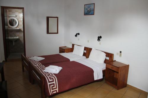 a bedroom with a large bed with two towels on it at Hotel Stavris in Khóra Sfakíon