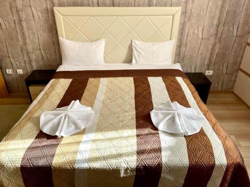 a bed with two white towels on top of it at Alpine Luxe Janosevic Kopaonik 011 in Kopaonik