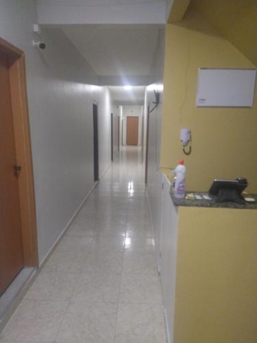 a hallway with a long corridor with a yellow wall at Hotel 678 in Boa Vista