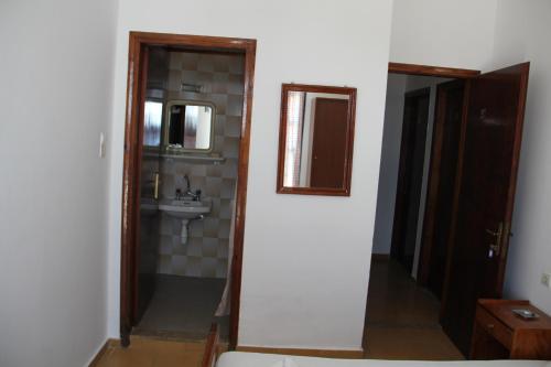 a bathroom with a sink and a toilet and a mirror at Hotel Stavris in Khóra Sfakíon