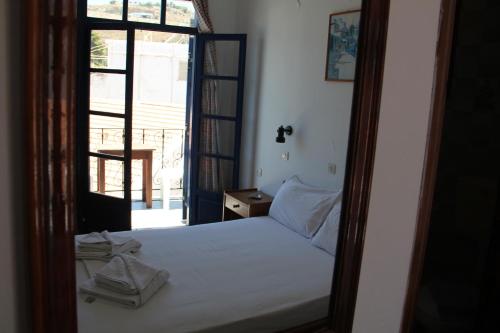 a bedroom with a bed and a door with a window at Hotel Stavris in Khóra Sfakíon