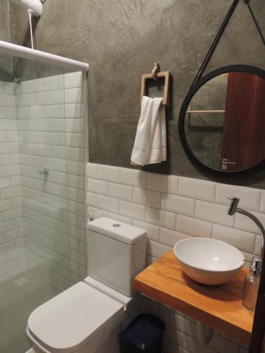 un bagno con un water, un lavandino e uno specchio di Aruna - Casa de Charme com piscina privativa a São Miguel dos Milagres