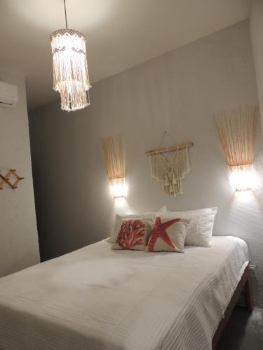 una camera con un letto bianco con due cuscini di Aruna - Casa de Charme com piscina privativa a São Miguel dos Milagres