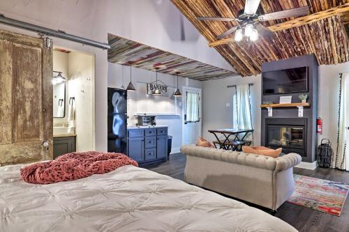 ein Schlafzimmer mit einem Bett und ein Wohnzimmer in der Unterkunft Fredericksburg Regan Cottage with Hot Tub! in Fredericksburg