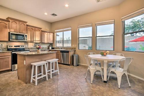 a large kitchen with a table and chairs and windows at Pool and Game Room Home in Goodyear Near Golfing in Liberty