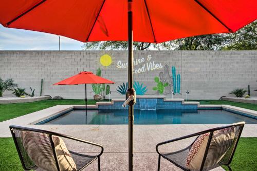a red umbrella and two chairs next to a pool at Pool and Game Room Home in Goodyear Near Golfing in Liberty