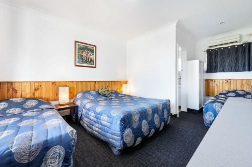 a hotel room with two beds and a table at Tamworth Budget Motel in Tamworth