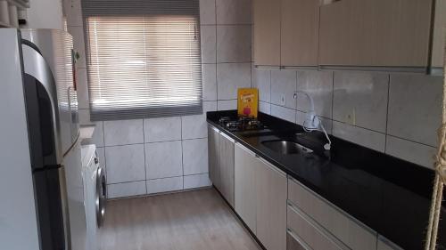 a kitchen with a sink and a counter top at Apartamento Inteiro jardim Iririú in Joinville