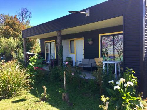 a small house with a porch and a patio at Cabañas ChiloeisLife Countryside in Castro