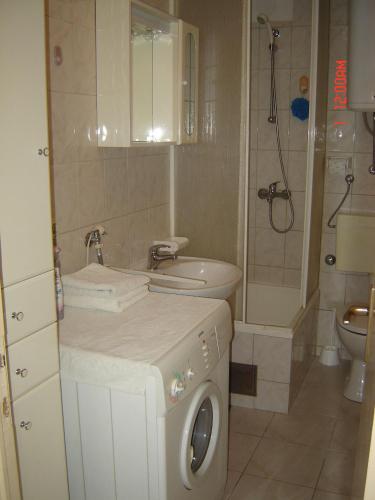 ein Badezimmer mit Waschmaschine und Waschbecken in der Unterkunft Apartment Bella in Split