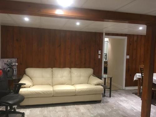 a white couch in a room with wooden walls at Chalet Ski Mont Calm Water Falls River Rawdon in Rawdon