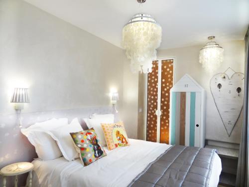 ein Schlafzimmer mit einem großen weißen Bett mit Kissen in der Unterkunft Le Pavillon Hotel in Paris