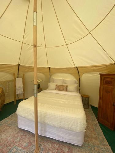 a bedroom with a bed in a tent at Belle Glamping by the Sea in Katikati