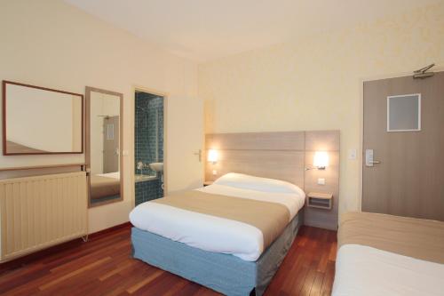 Postel nebo postele na pokoji v ubytování Grand Hotel du Loiret