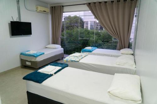 a room with three beds and a window at Flat Central in Bonito