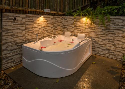 a white bath tub sitting in a yard with lights at Ecohotel Piedemonte in Salento