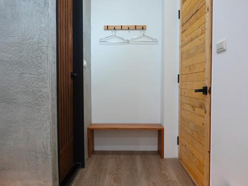 a hallway with a wooden bench next to a door at Summerflow Hostel in Xiaoliuqiu