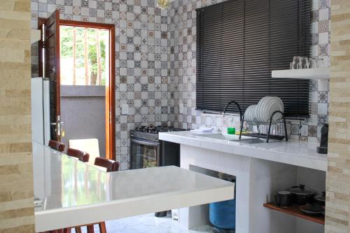 a kitchen with a white counter and a stove at Harmonia Flats in Pipa