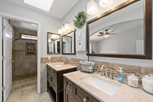 a bathroom with two sinks and a large mirror at Playpool Oasis-Pool, Spa, Garage, Great Lake Views in Lake Havasu City