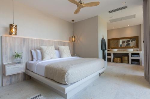 a bedroom with a white bed and a ceiling fan at Cielo Boutique Hotel & Spa Samui in Bophut 