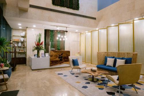 a lobby with a blue couch and chairs and a table at Goldberry Suites and Hotel Cebu in Cebu City