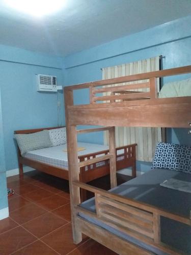 Zimmer mit 2 Etagenbetten und einem Bett in der Unterkunft BALAY TURISTA TRANSIENT HOUSE in Alaminos