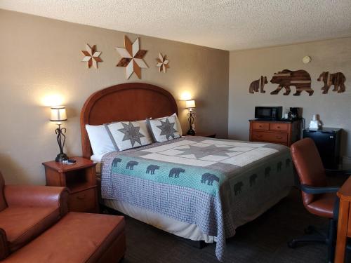 a hotel room with a bed and a chair at Kansas Country Inn in Oakley
