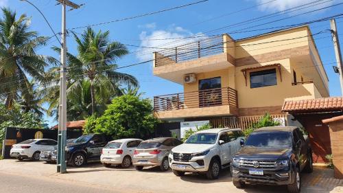 un grupo de autos estacionados frente a una casa en Harmonia Flats en Pipa