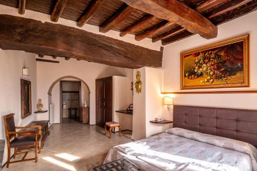 HOTEL TREVI Palazzo Natalini في تريفي: غرفة نوم بسرير ودهان على الحائط
