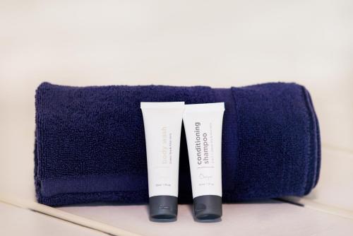 two tubes of sunscreen sitting on a blue towel at Airlie Beach Magnums - Adults Only in Airlie Beach