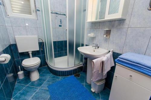 uma casa de banho com um lavatório, um WC e um chuveiro em Apartments Iva - 150m from the beach em Trogir