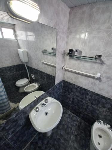 a bathroom with two toilets and a sink at Apartamento Piriápolis in Piriápolis