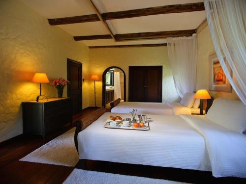 a bedroom with two beds with a tray of fruit on the bed at Sarova Lion Hill Game Lodge in Nakuru