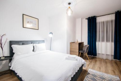 1 dormitorio con 1 cama blanca grande y escritorio en Roua Bucovinei en Sadova