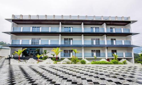 a building with blue balconies and a checkered floor at Treebo Trend Misty Garden Resorts With Mountain View in Munnar