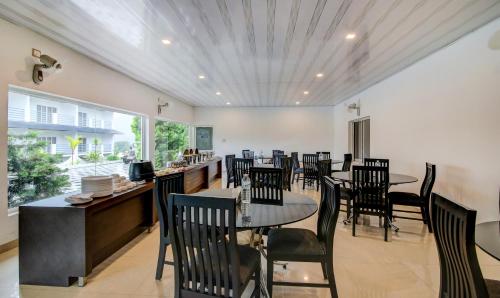 a dining room with tables and chairs in a restaurant at Misty Garden Resort and SPA in Munnar
