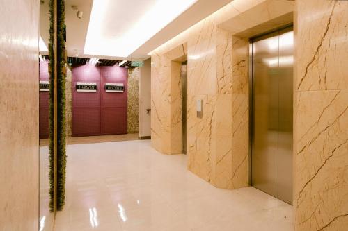 a hallway with purple doors and marble walls at Goldberry Suites and Hotel Cebu in Cebu City