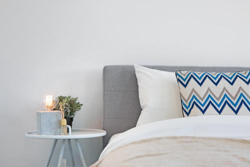a bedroom with a bed and a side table at KOZYGURU WENTWORTHVILLE KOZY 2 BED 1 BATH APT STREET PARKING NWE049 in Wentworthville