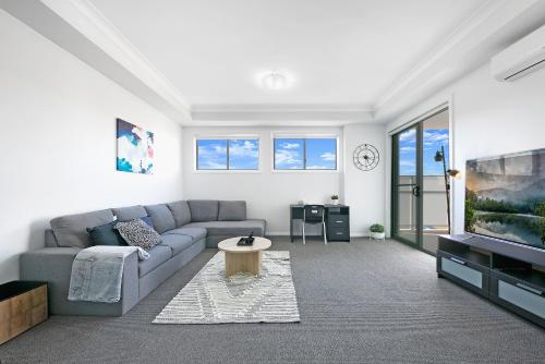 a living room with a couch and a tv at KOZYGURU WENTWORTHVILLE KOZY 2 BED 1 BATH APT STREET PARKING NWE049 in Wentworthville