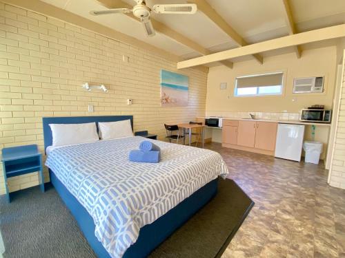 a bedroom with a large bed and a kitchen at Rye Beach Motel Australia in Rye