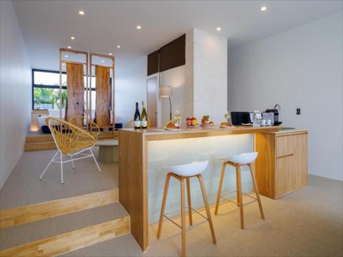 a kitchen with a counter and stools in a room at ADAN RESORT Sky Villa Luxury Suite in Motobu