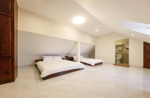 a large bedroom with two beds and a bathroom at Bonjour Da Lat Hotel in Da Lat