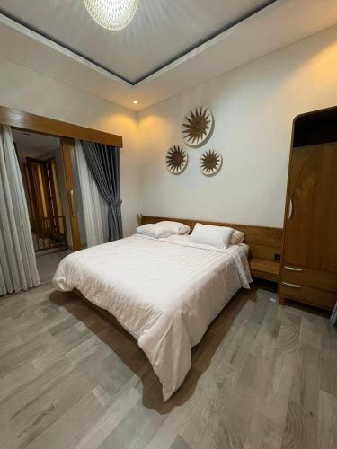 a bedroom with a bed and two mirrors on the wall at Marades Tropical Villa in Ngingas