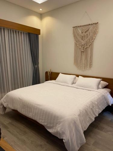 een slaapkamer met een groot wit bed en een raam bij Marades Tropical Villa in Ngingas
