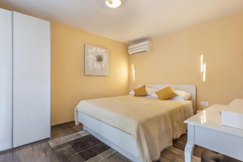 sypialnia z łóżkiem z żółtymi ścianami w obiekcie Villa Vita in Poreč - Haus für 6-8 Personen w mieście Kaštelir