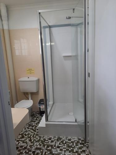 a shower stall in a bathroom with a toilet at Hay Point Hotel/Motel in Hay Point
