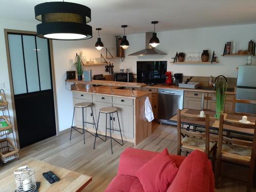 a living room with a couch and a kitchen at Le logis du héron in Coulon